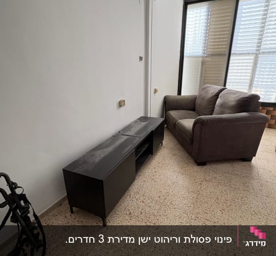 ספה ושידה בחדר עם חלון גדול